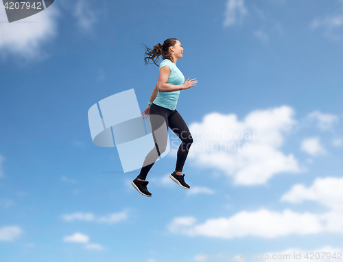 Image of happy smiling sporty young woman jumping in air