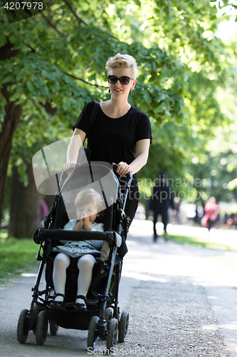 Image of mother pushed her baby daughter in a stroller