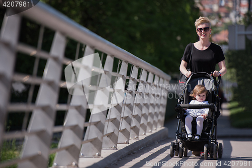 Image of mother pushed her baby daughter in a stroller