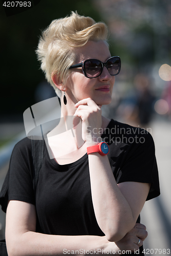 Image of young woman with short blond hair and sunglasses