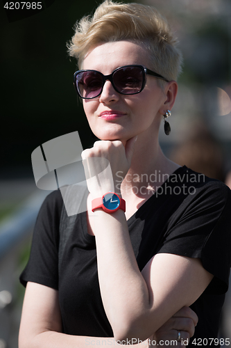 Image of young woman with short blond hair and sunglasses
