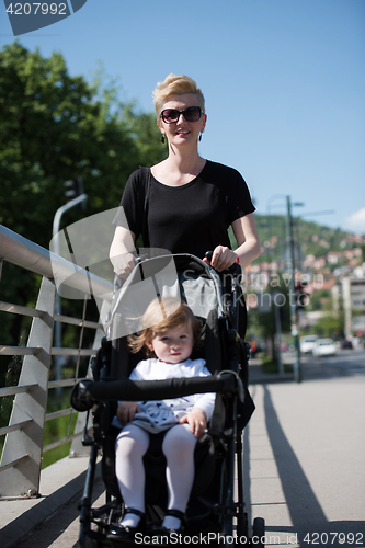 Image of mother pushed her baby daughter in a stroller