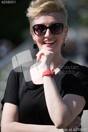 Image of young woman with short blond hair and sunglasses