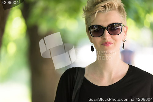 Image of young woman with short blond hair and sunglasses