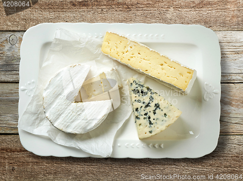 Image of plate of various cheese on wooden table