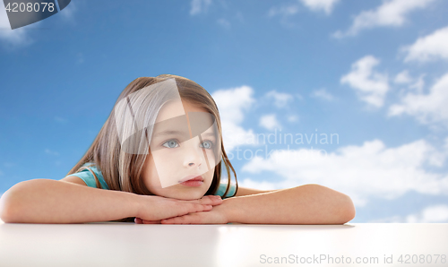 Image of beautiful sad girl over blue sky and clouds
