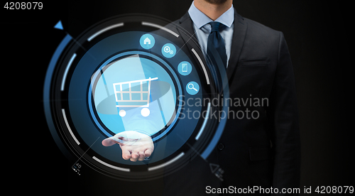 Image of businessman with virtual shopping cart projection