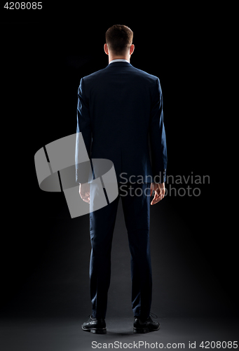 Image of businessman in suit over black