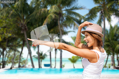 Image of happy young woman in hat on summer beach