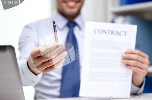 Image of businessman with contract paper and pen at office