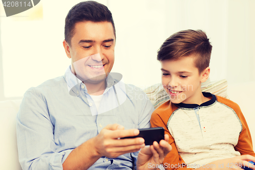Image of happy father and son with smartphone at home