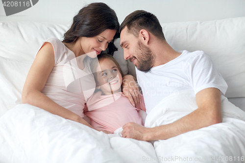 Image of happy family in bed at home