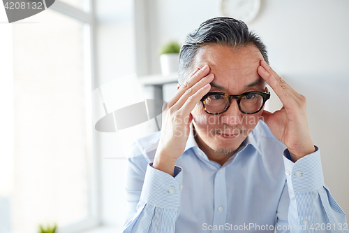 Image of anxious businessman in eyeglasses at office