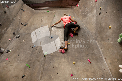 Image of young woman exercising at indoor climbing gym