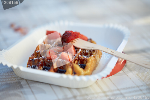 Image of waffle with strawberry on paper plate and fork