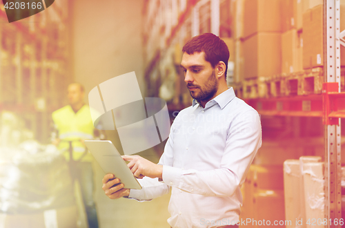 Image of businessman with tablet pc at warehouse