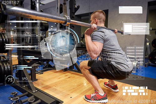 Image of young man flexing muscles with bar in gym