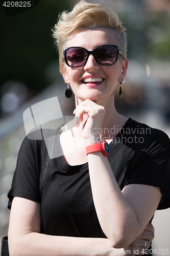 Image of young woman with short blond hair and sunglasses