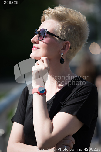 Image of young woman with short blond hair and sunglasses