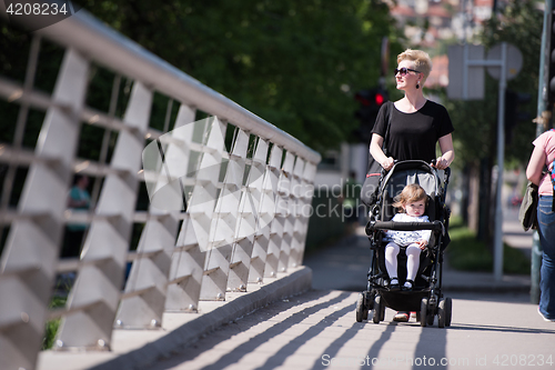 Image of mother pushed her baby daughter in a stroller