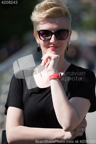 Image of young woman with short blond hair and sunglasses