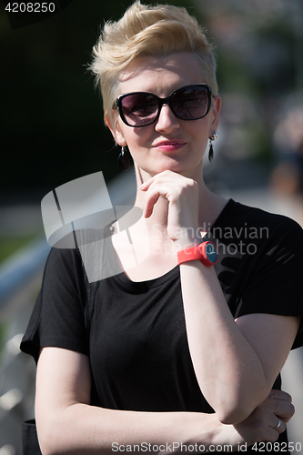 Image of young woman with short blond hair and sunglasses