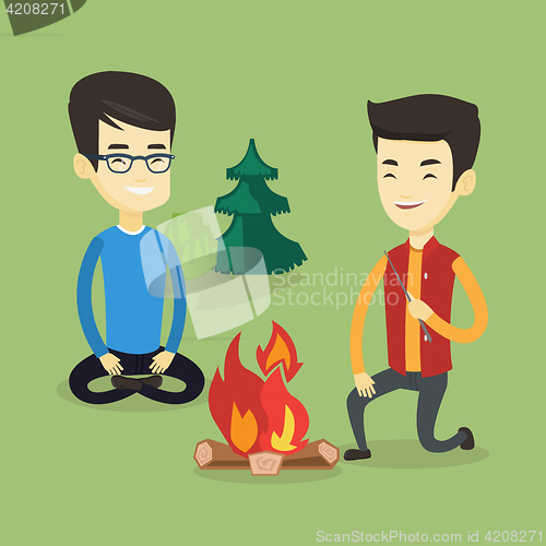 Image of Two friends sitting around bonfire in camping.