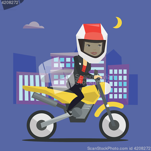 Image of Woman riding motorcycle at night.