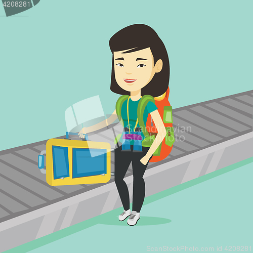 Image of Woman picking up suitcase on luggage conveyor belt