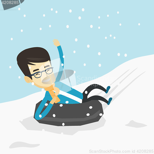 Image of Man sledding on snow rubber tube in the mountains.