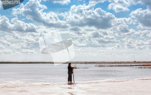 Image of Man By The Lake Among Quartz Sand Under Beautiful Cloudy Sky