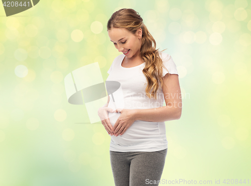 Image of happy pregnant woman showing heart gesture