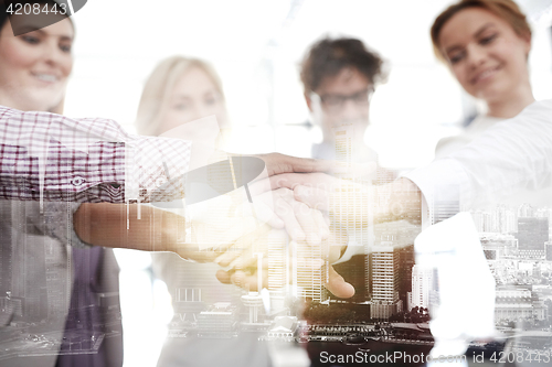 Image of happy business team with hands on top at office