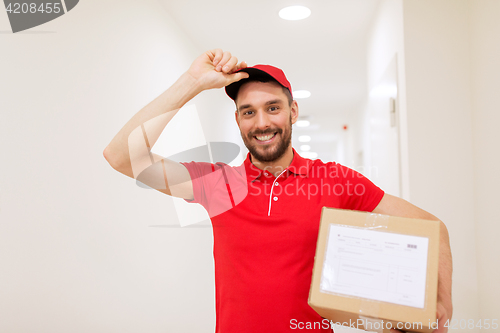 Image of delivery man with parcel box in corridor