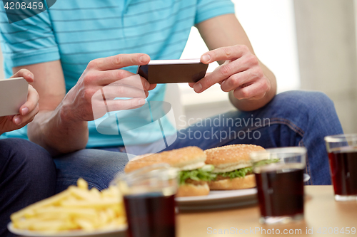 Image of friends with smartphones taking picture of food