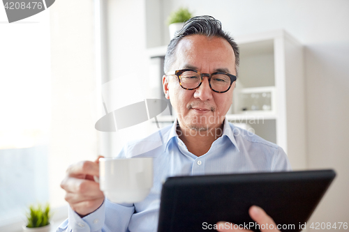 Image of businessman with tablet pc and coffee at office