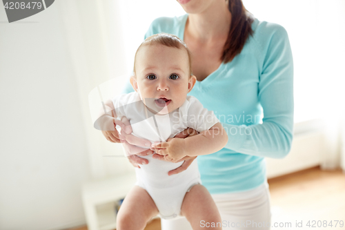 Image of happy young mother with little baby at home