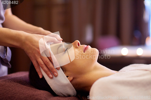 Image of woman having face and head massage at spa