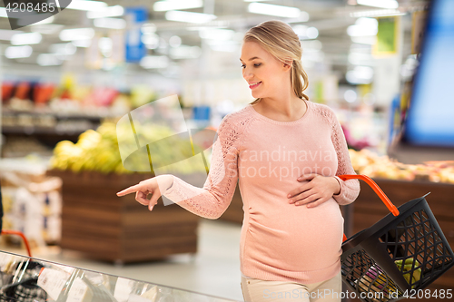 Image of pregnant woman with shopping basket at grocery