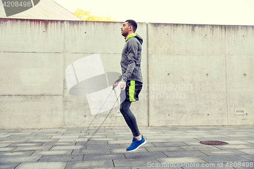 Image of man exercising with jump-rope outdoors