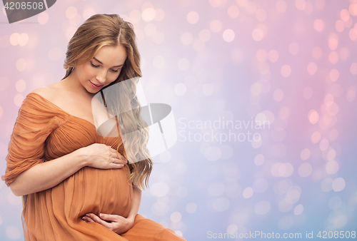 Image of happy pregnant woman touching her big belly