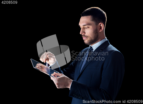 Image of businessman in suit with transparent tablet pc