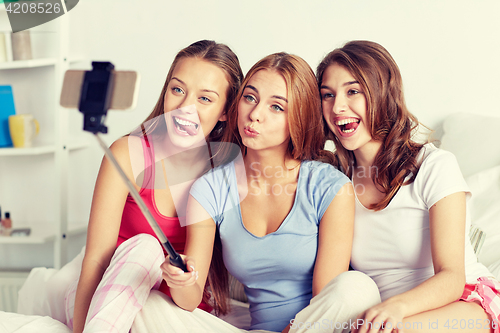 Image of teen girls with smartphone taking selfie at home