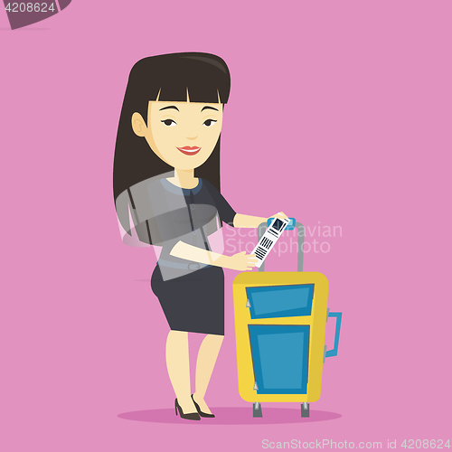 Image of Asian business woman showing luggage tag.