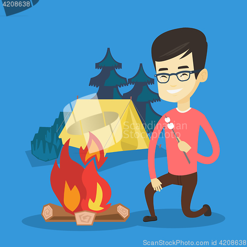 Image of Young man roasting marshmallow over campfire.