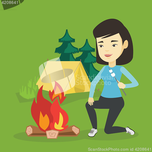 Image of Woman roasting marshmallow over campfire.