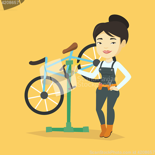 Image of Asian bicycle mechanic working in repair shop.