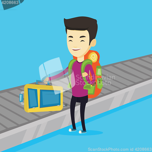 Image of Man picking up suitcase on luggage conveyor belt