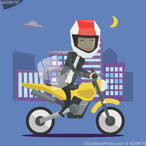 Image of Young man riding motorcycle at night.