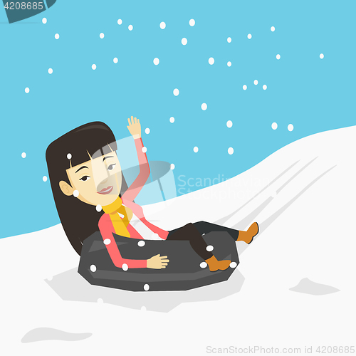 Image of Woman sledding on snow rubber tube in mountains.